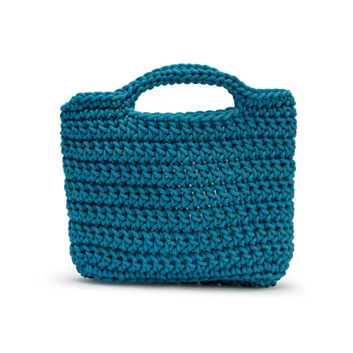 Handmade Crochet Clutch Bag – A Modern Spin on Tradition Crafted for those who love texture and timelessness, this handmade crochet clutch bag is a true statement piece. Designed in a rich teal tone and intricately hand-knotted using thick yarn, it balances softness with structure. Its compact square shape and short handle make it perfect for casual days, artisan markets, or dressier evening events. The unique form blends the practicality of a mini crochet tote bag with the elegance of a clutch purse — ideal for those looking to break free from conventional handbags. Key Features: 100% hand-crocheted with durable yarn Stylish teal blue colour for year-round wear Boxy square silhouette with integrated handle Fits daily essentials like phone, keys, and wallet Lightweight and foldable for on-the-go versatility Whether you’re browsing for crochet clutch bags or looking to update your crochet tote collection, this piece offers both function and flair.