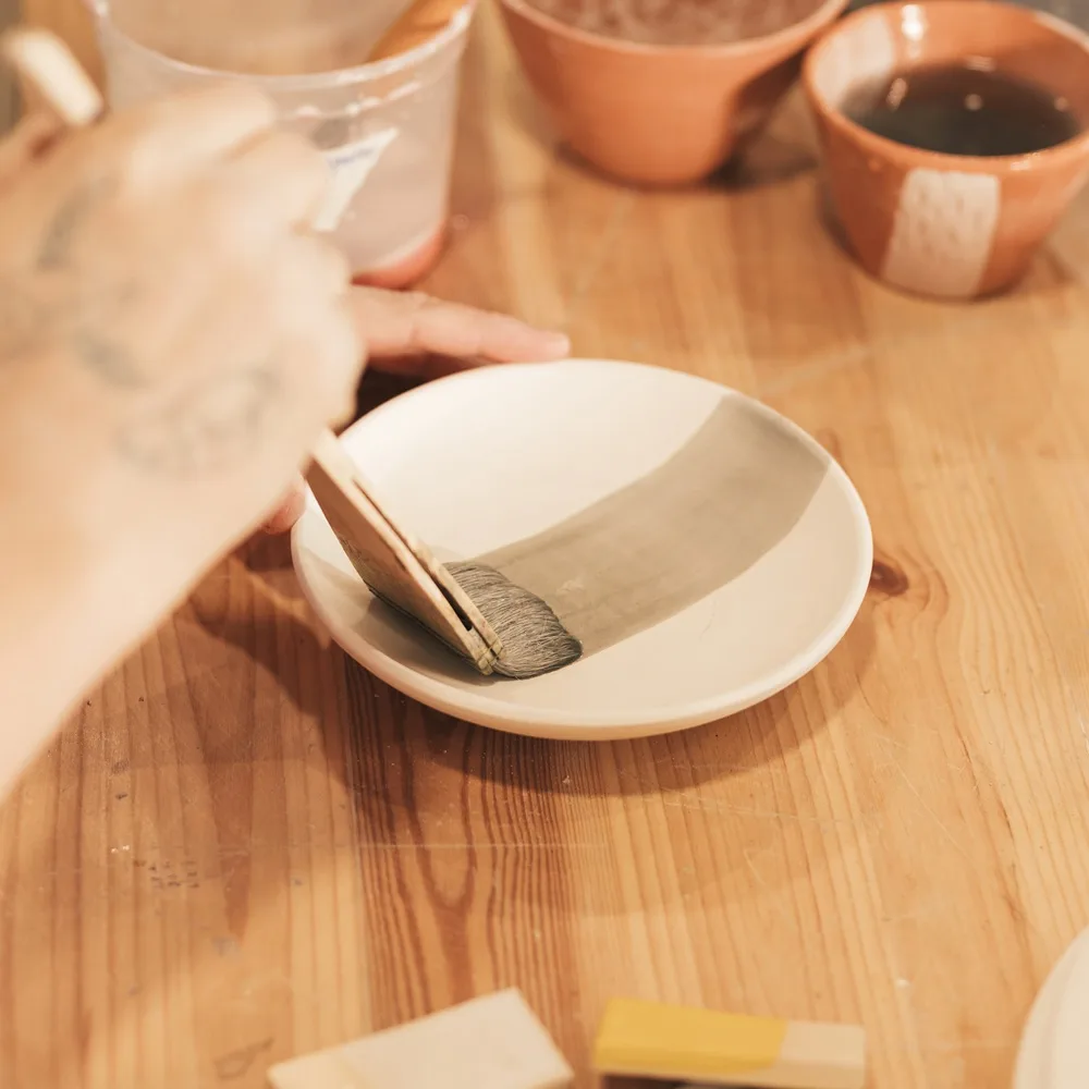 A Woman taking care of a Pottery Bowl.